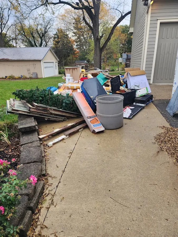 Dumpster being loaded with debris for 12 Yard Dumpster Rental in Bettendorf